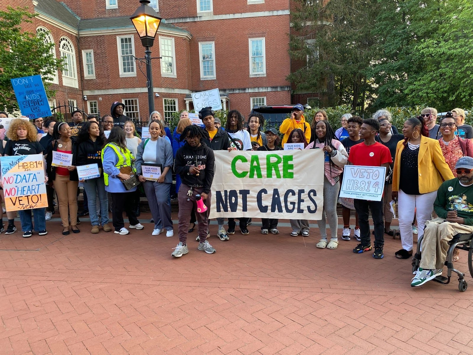 JUFJ and our partners holding up signs advocating for youth justice and "Care, not Cages"